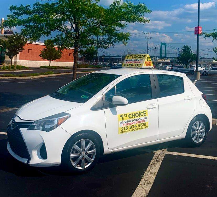 A white car with a yellow sign on the side.